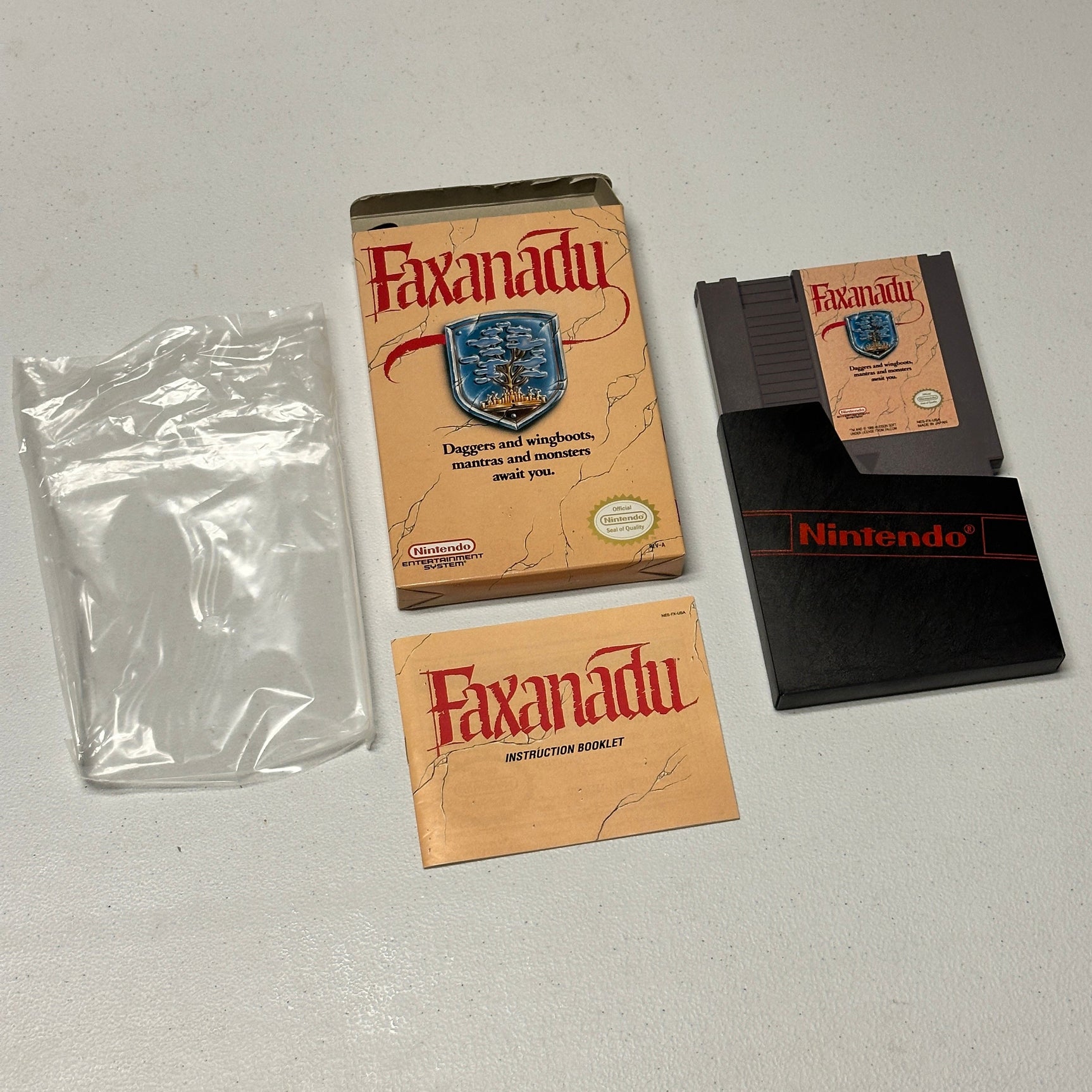 Nintendo Faxanadu game cartridge, box, and manual on a gray surface