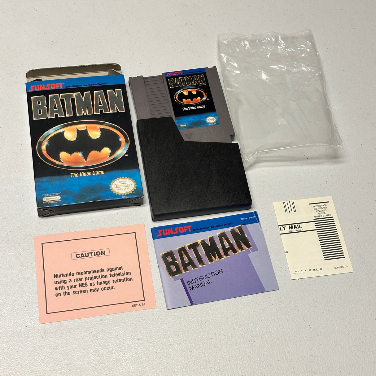 Batman video game cartridge and packaging on a gray surface